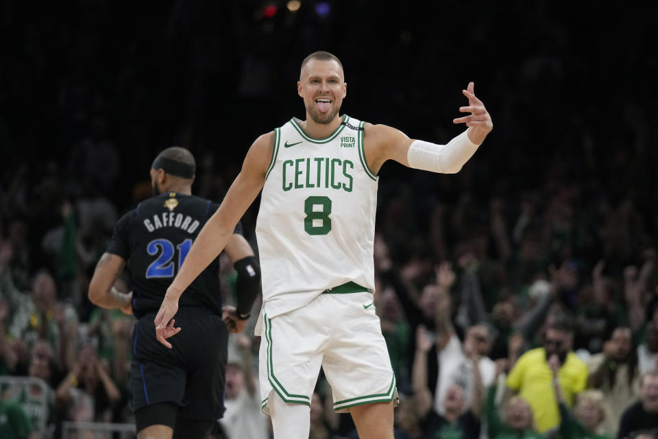 Center Boston Celtics Kristaps Porzingis (8) merayakan tembakan tiga angka di dekat center Dallas Mavericks Daniel Gafford (21) pada paruh pertama Game 1 Final NBA bola basket pada Kamis, 6 Juni 2024. Di Boston (AP Photo/Charles Krupa)