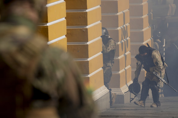 Tentara berjalan di tengah tembakan gas air mata di luar Gedung Legislatif di Plaza Murillo, La Paz, Bolivia.
