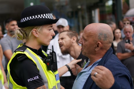 A police officers speaks to a man as people demonstrate in Nottingham Market Square on Saturday.