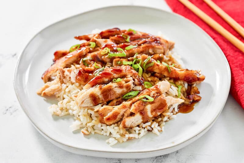 Ayam teriyaki panggang Copycat Panda Express di atas nasi di piring.
