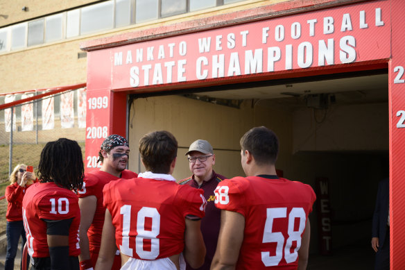 Tim Walz berbicara dengan para pemain di tim sepak bola Mankato West.
