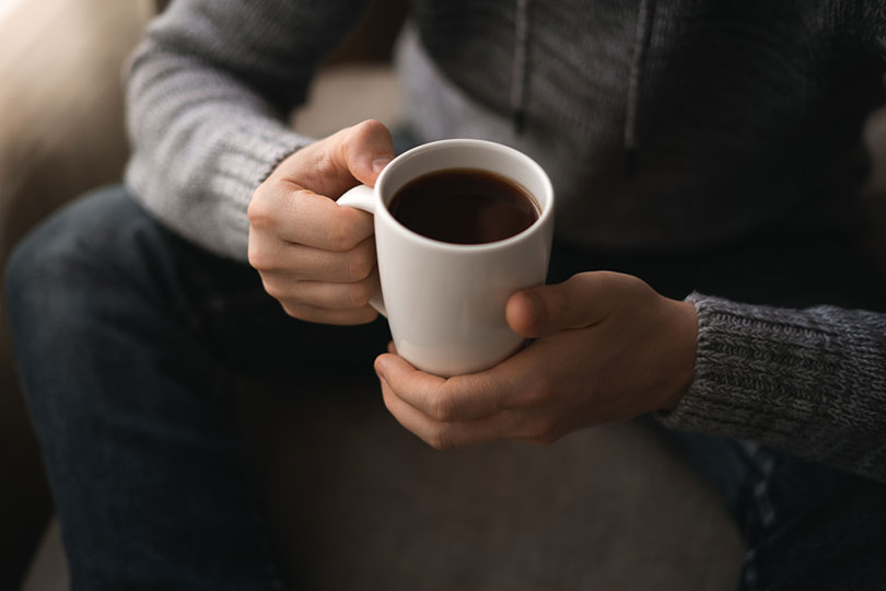 seorang pria dengan secangkir kopi