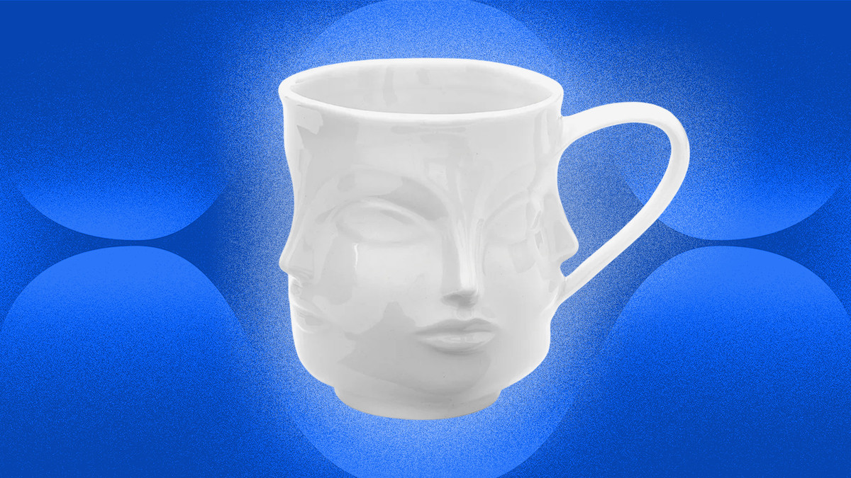 Mug putih dengan ukiran wajah.