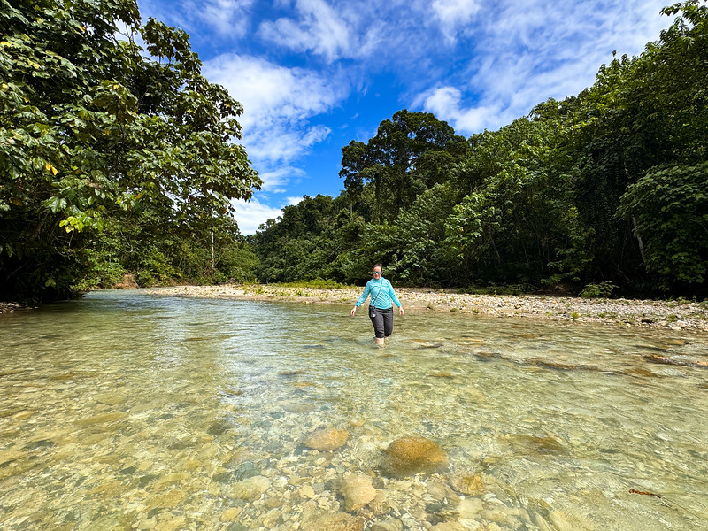 Lina Stock crossing a river on the hiking trail to Tenaru Falls in the Solomon Islands