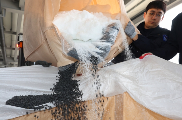 Seorang petugas bea cukai di Bea Cukai Regional Seoul menampilkan kedelai hitam yang disembunyikan di dalam kantong ton berlabel mengandung larutan air urea pada hari Kamis. (Yonhap)