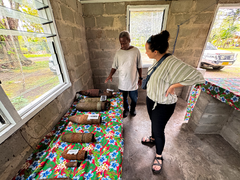 Lina Stock looking at large WWII ammunition with the owner of the Vilu War Museum on Guadalcanal, Solomon Islands