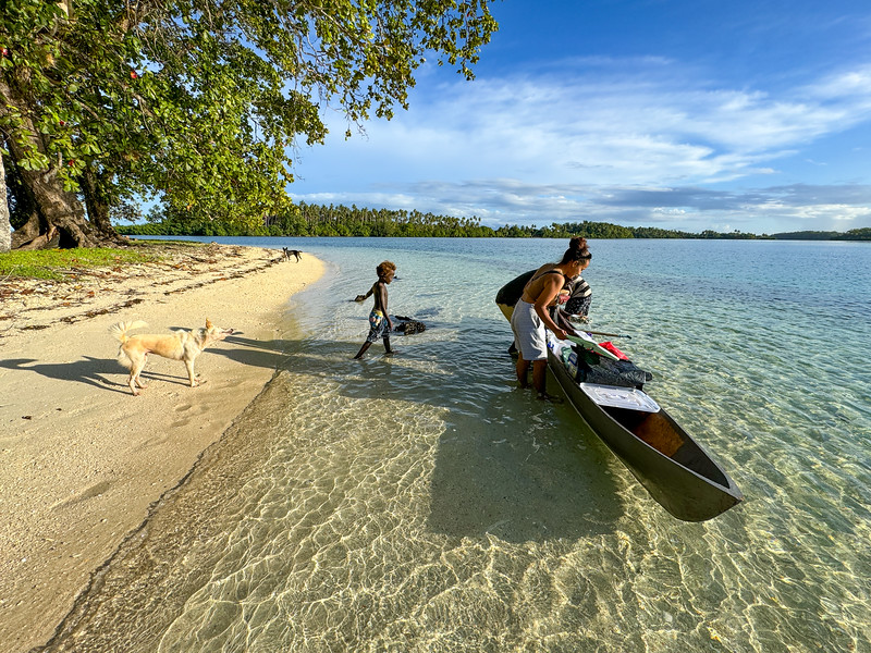 People buying fish from a canoe at Hopei Island in the Solomon Islands