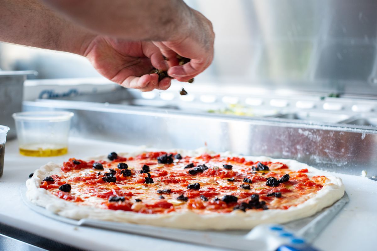 Chef Steve Samson builds a thin crust pizza at Superfine Pizza.