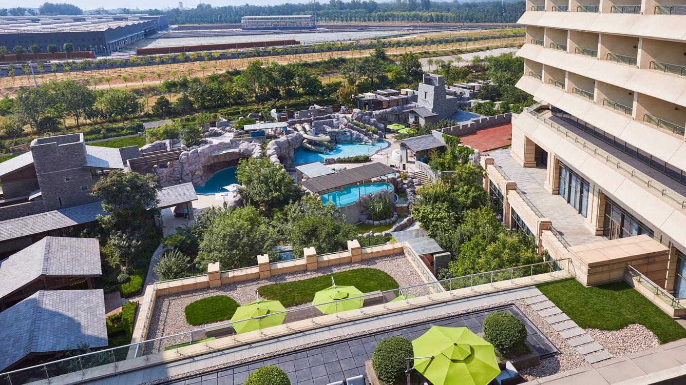 Resor Marriott Mewah dengan area kolam renang luar ruangan yang indah, slide air dengan tema, tanaman hijau subur dan arsitektur modern