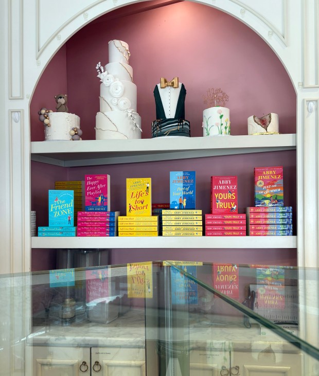 Kue dan buku ditumpuk di kabinet reflektif di meja kaca.