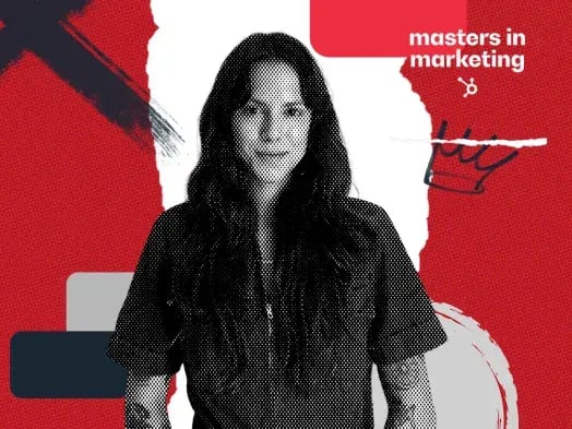 Seorang wanita dengan rambut hitam panjang, kemeja lengan pendek dan tato lengan.