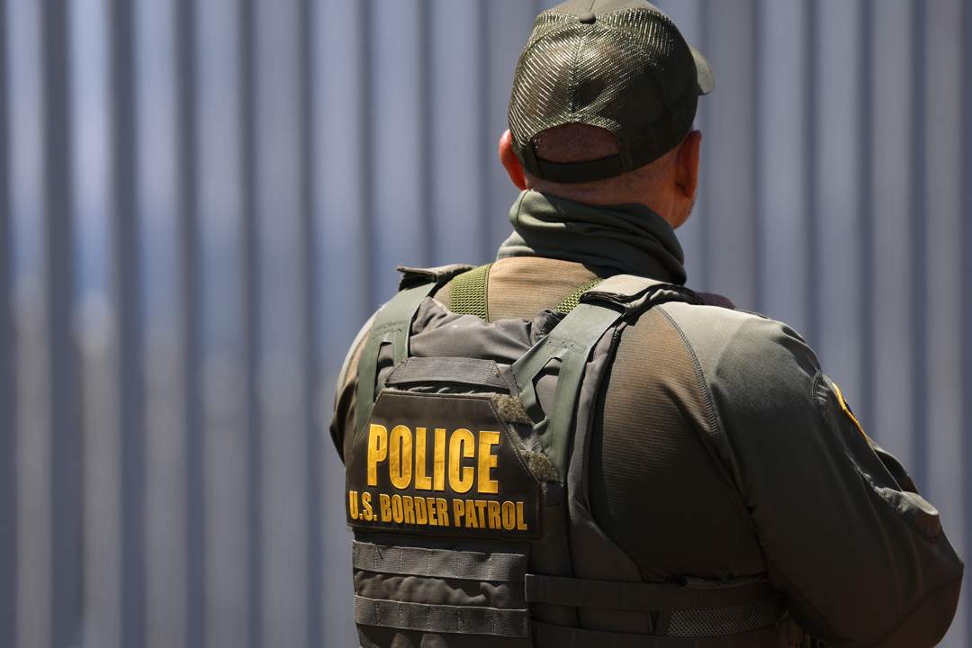 Patroli Perbatasan Bea Cukai dan Perbatasan (CBP) AS berdiri di Taman Lapangan Perbatasan di latar belakang Empire Beach, California.