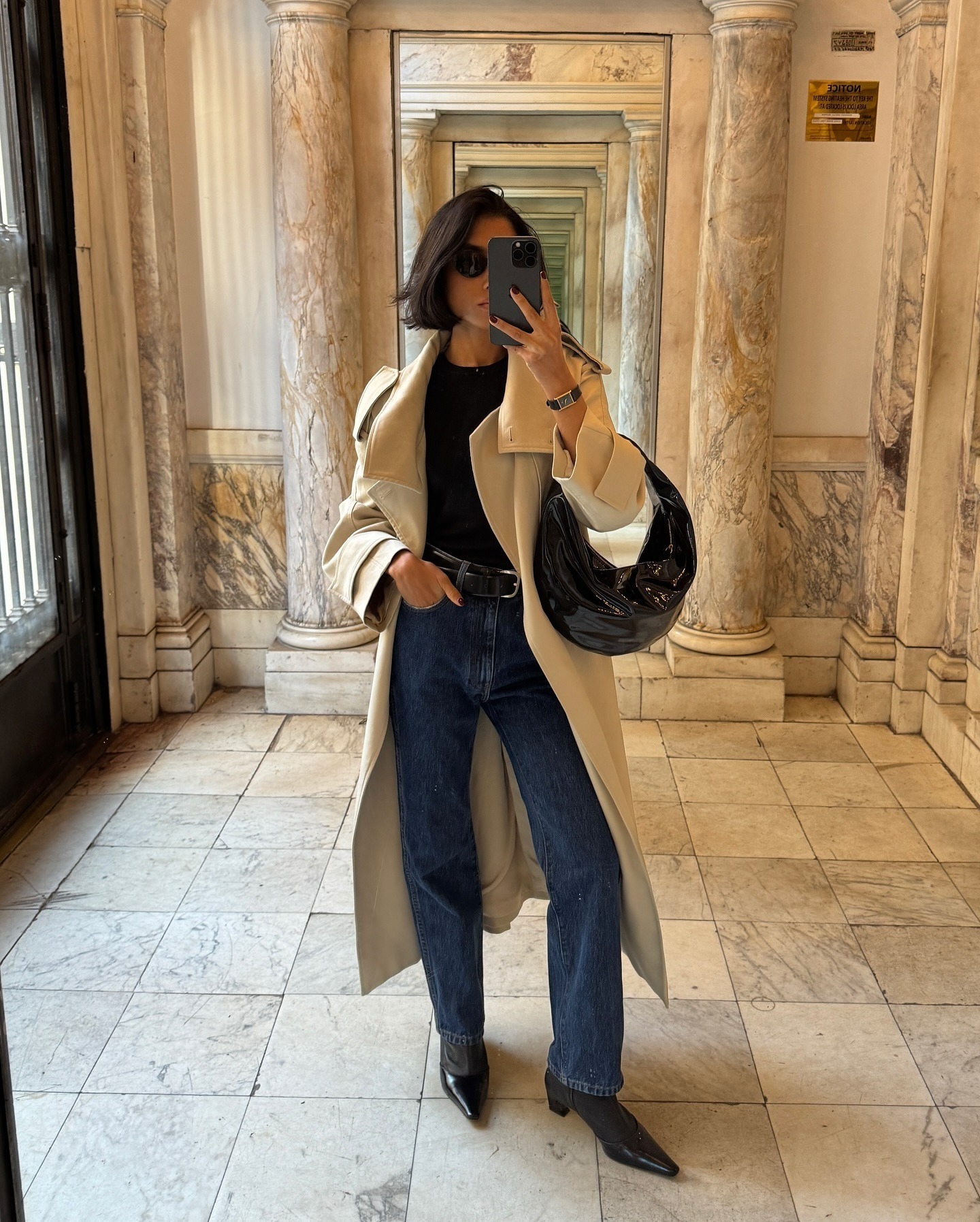 Influencer tersebut mengenakan mantel panjang dengan jeans dan sepatu bot semata kaki.