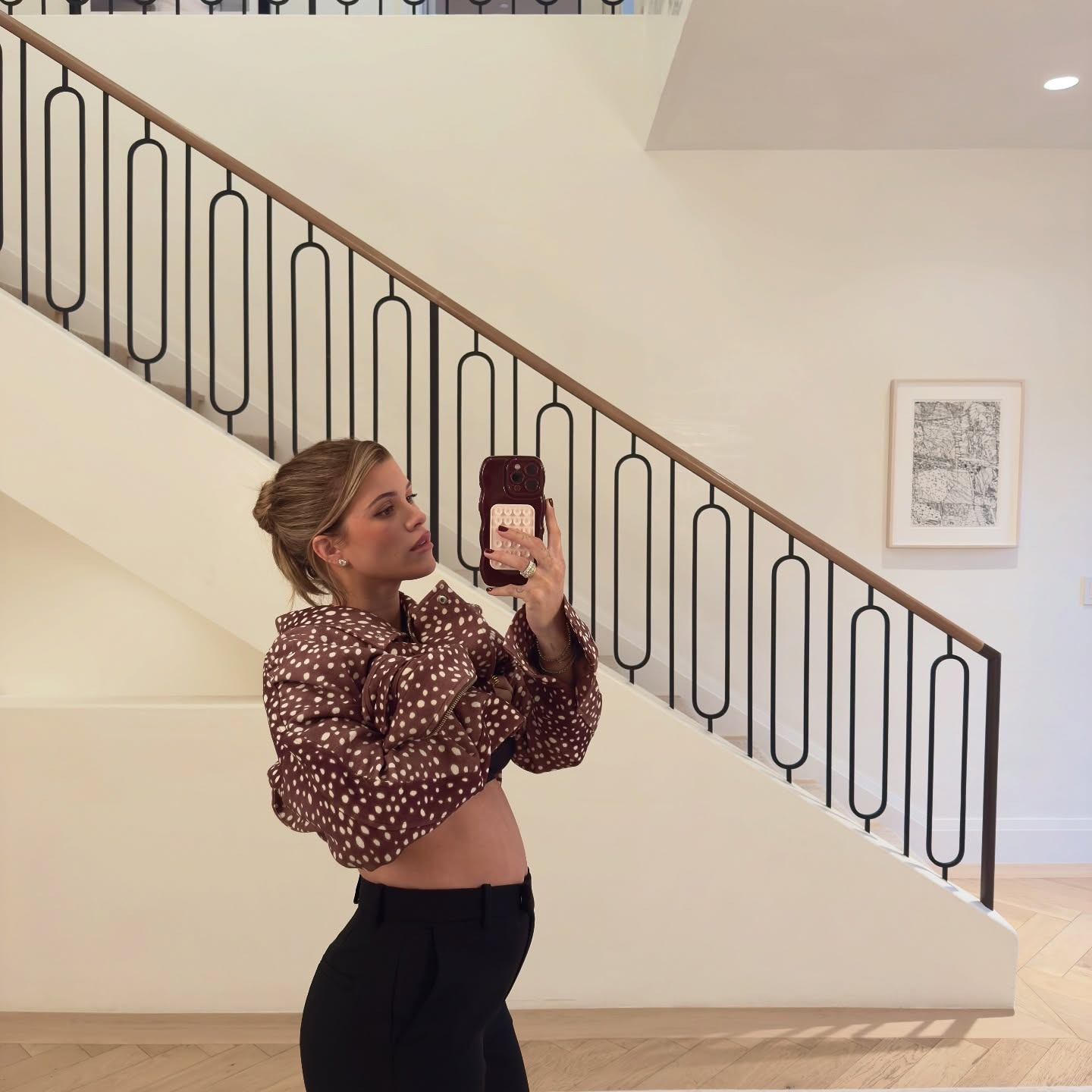 Sofia Richie Grainge mengumumkan kehamilan keduanya dengan jaket bermotif sapi SRG dan celana hitam.