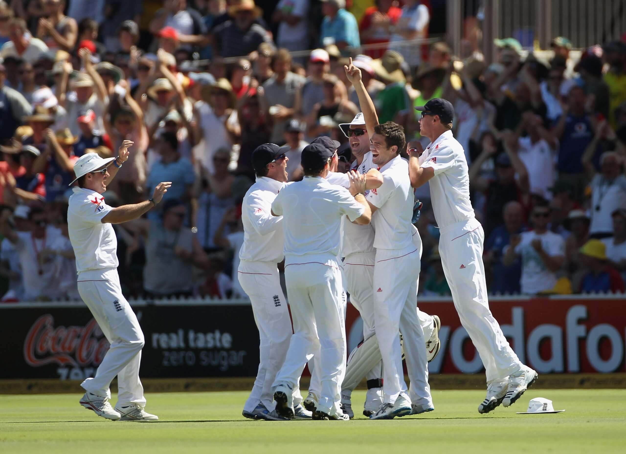 England's players mob Jonathan Trott after he runs out Simon Katich in Adelaide