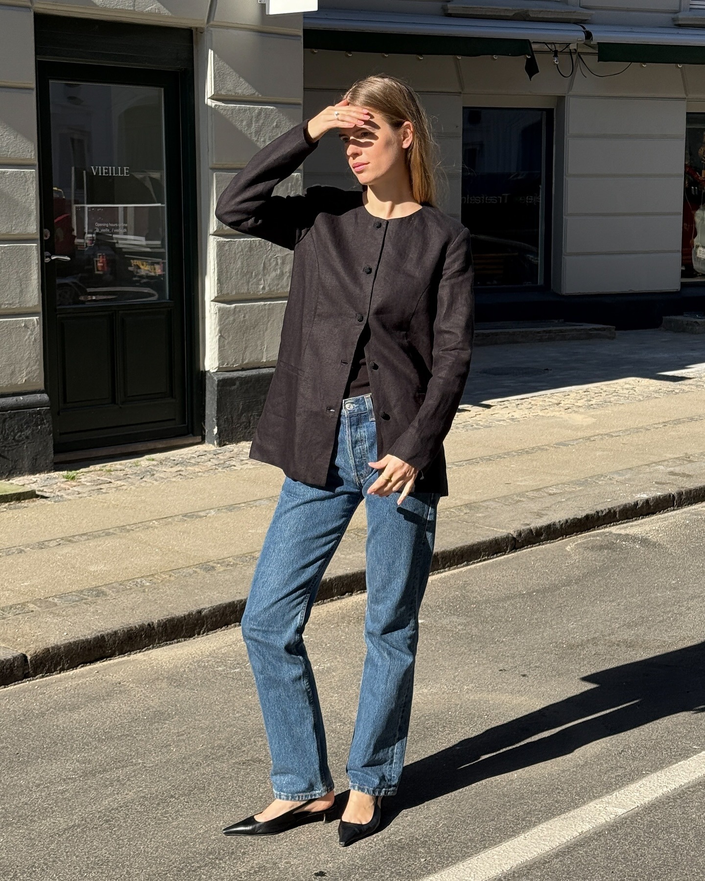 Influencer @claradyrhauge Kenakan blazer tanpa kerah. Padukan dengan jeans straight leg berwarna biru. dan sandal hak kucing dengan ujung tertutup.