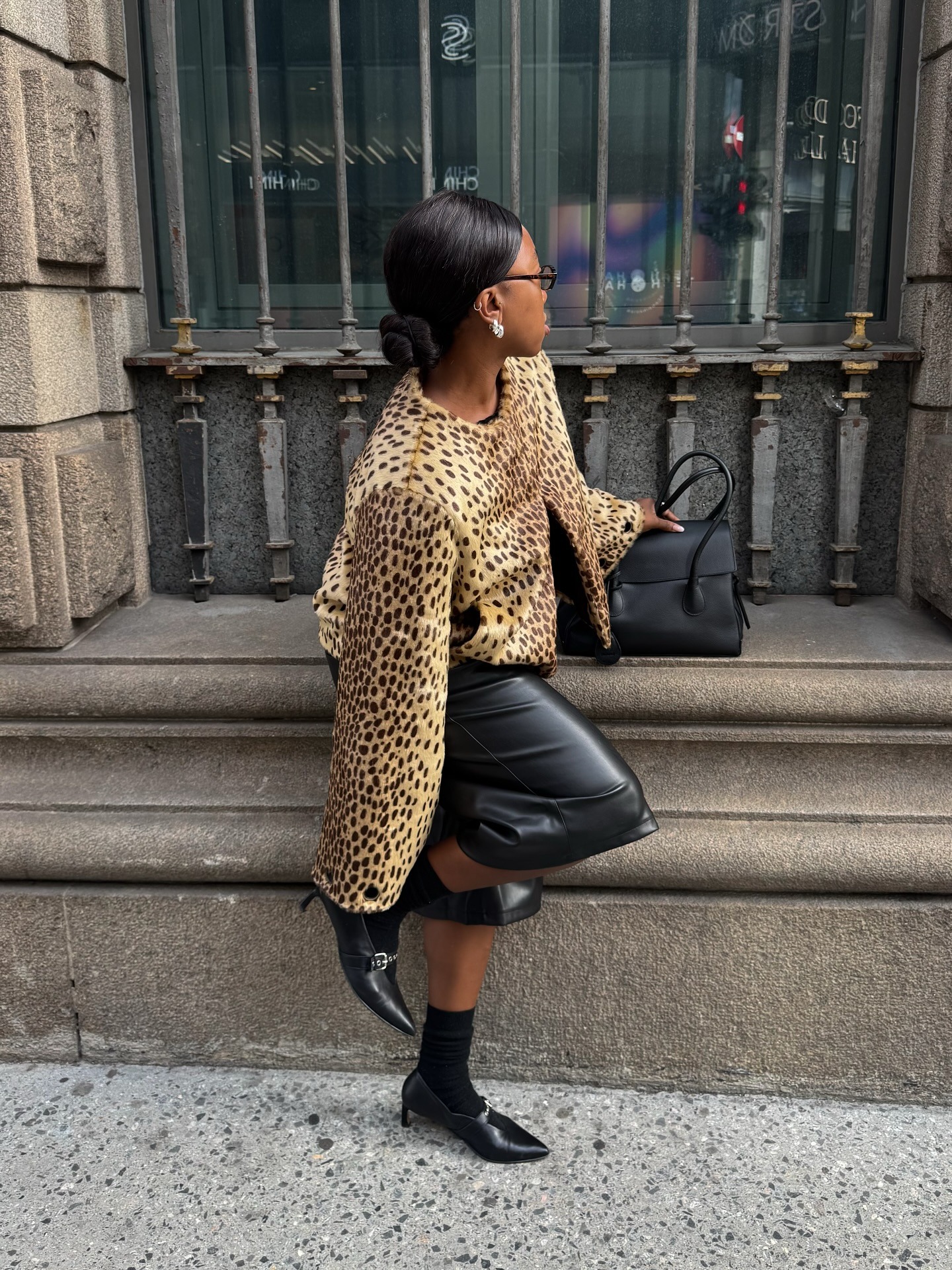 Influencer @nnennaechem mengenakan jaket bermotif macan tutul. Padukan dengan celana pendek kulit. dan sepatu flat hitam dengan ujung tertutup