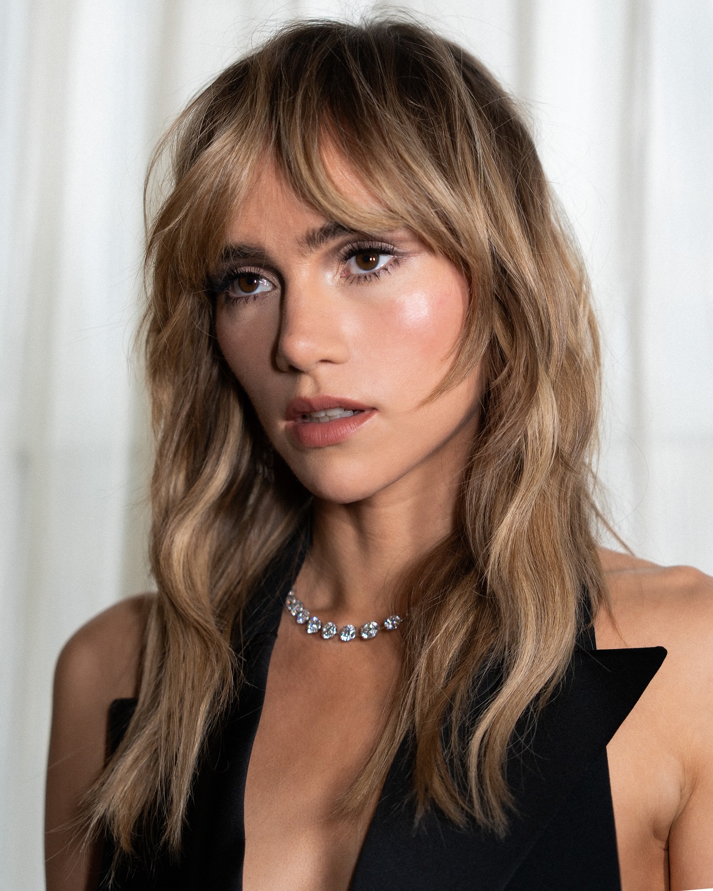 Suki Waterhouse, poni Birkin, memakai atasan halter hitam.