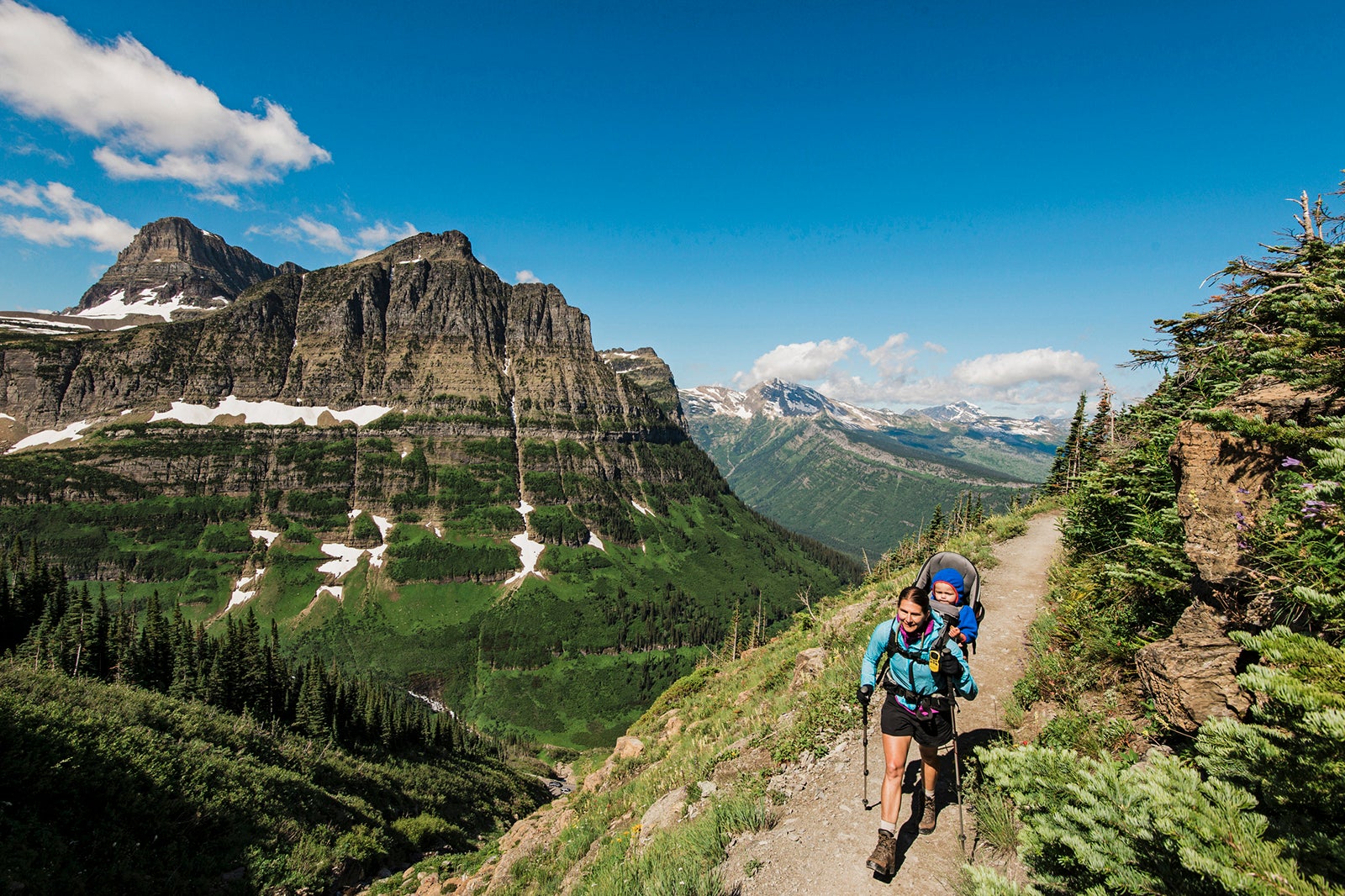 Wanita dan anak-anak mendaki Highline Trail di Taman Nasional Glacier, Montana.