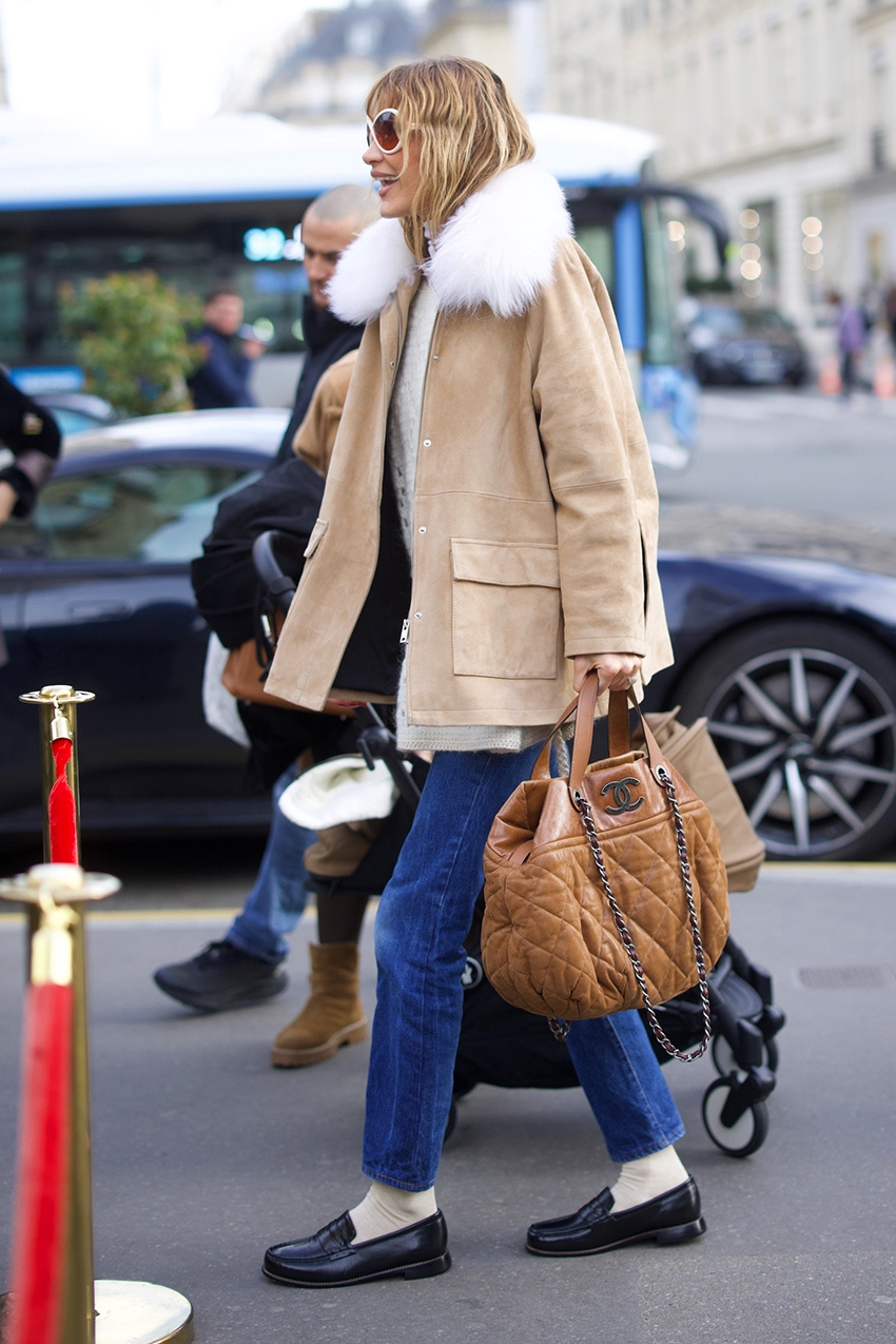 Bella Hadid mengenakan mantel coklat. Sweater berwarna krem ​​Jeans, kaus kaki, dan sepatu pantofel berkobar di Paris selama PFW F/W 26